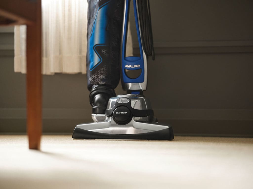 Kirby vacuum cleaning bedroom carpet.