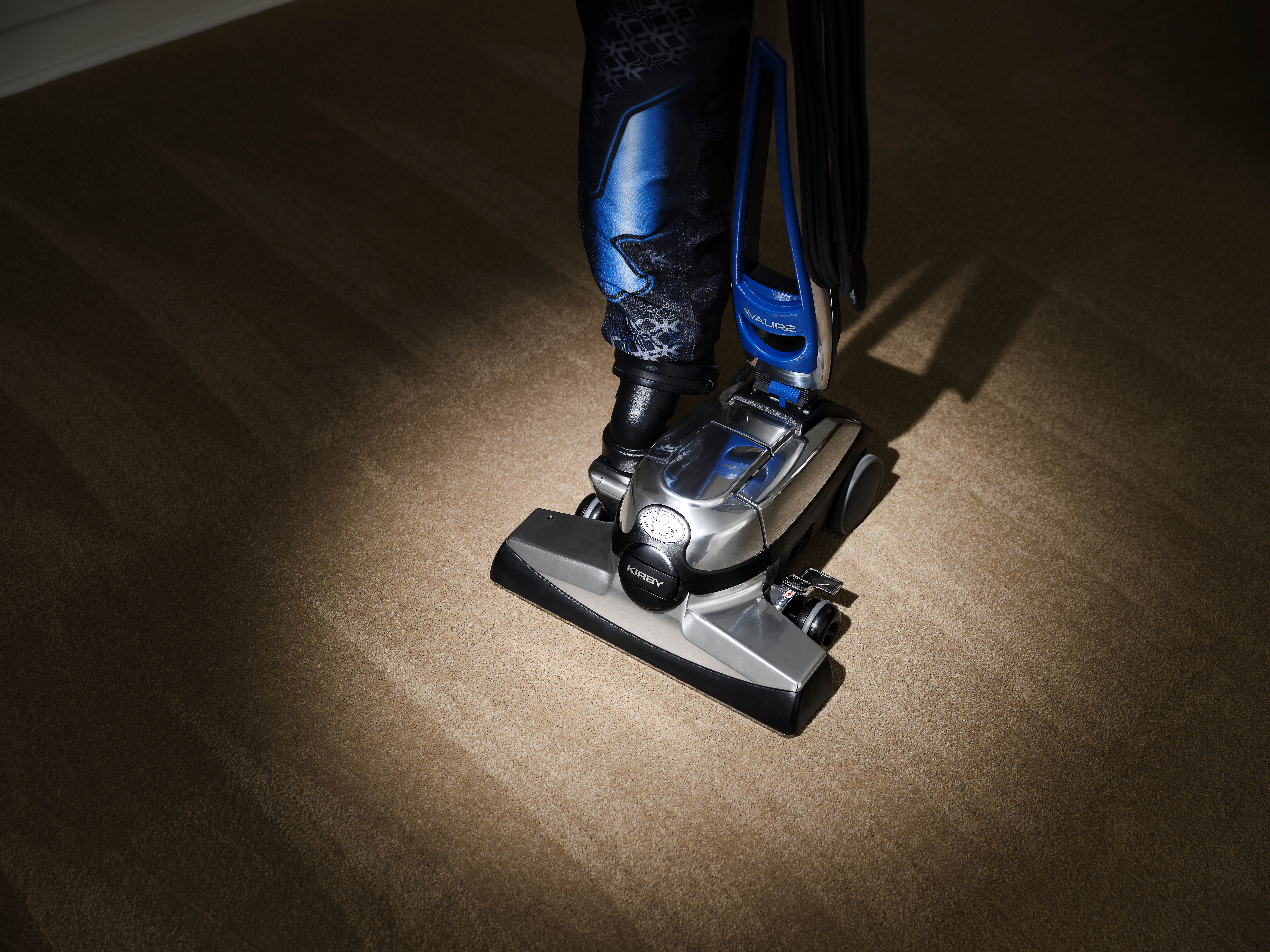 A spotlight illuminating a Kirby vacuum cleaner on the floor