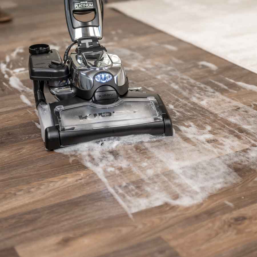 A Kirby vacuum with it's multi-surface shampoo system cleaning a hard wood floor